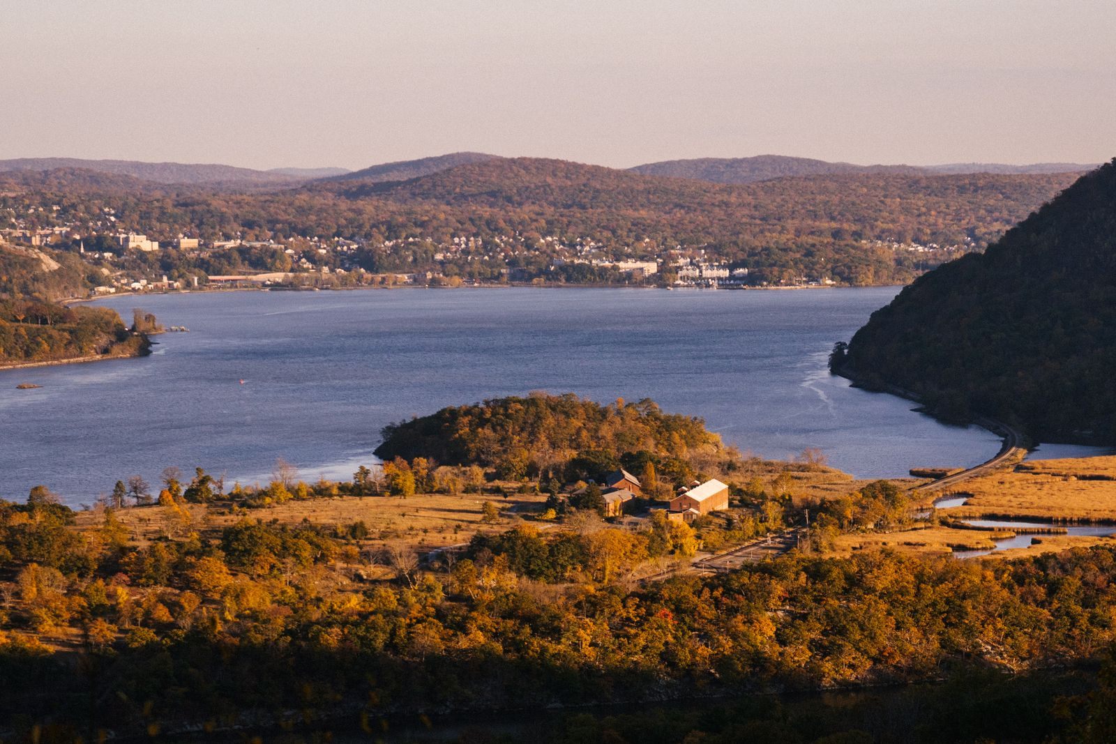 Autumn color on the hills of the Hudson Highlands above a bend of the river, the classic view on Hudson River cruises