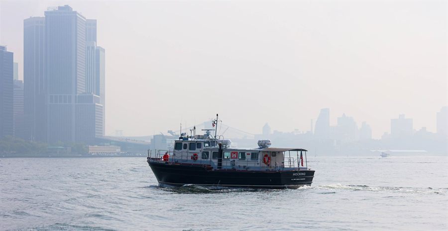 A small boat on the Hudson with Manhattan towers fading into fog